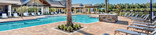 a swimming pool with chairs and palm trees