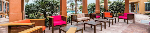 a patio with chairs and tables and a pool