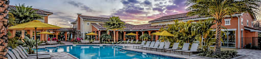 a swimming pool with chairs and palm trees