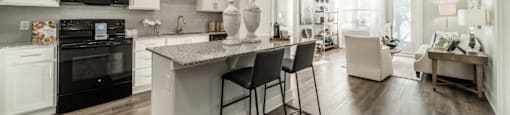 an open kitchen and living room with a marble counter top