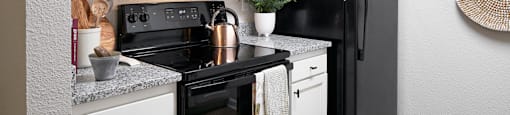 our apartments offer a kitchen with black appliances and white cabinets