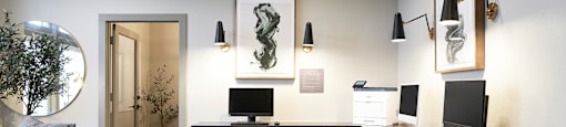 a office with a desk with three monitors and a couch