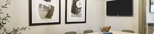 a conference room with a table and chairs and pictures on the wall