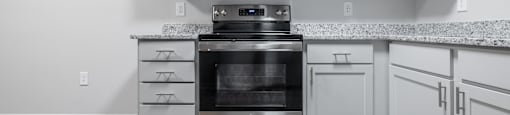 a kitchen with white cabinets and a stove and microwave