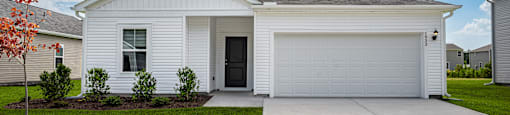 a white house with a driveway and a garage door