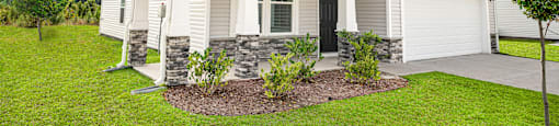 a white and gray house with a lawn and a driveway