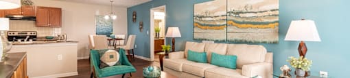 A living room with a blue rug and a painting on the wall.