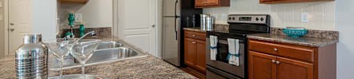 A kitchen with brown cabinets and a granite countertop.