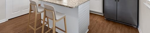 A kitchen with a granite countertop and stainless steel appliances.