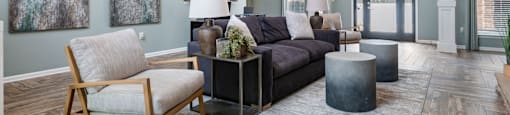 A living room with a wooden chair and a grey couch.