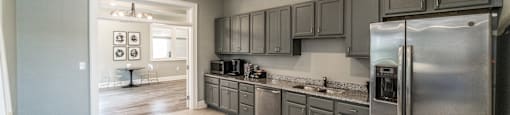 A kitchen with a refrigerator, cabinets, and a counter.