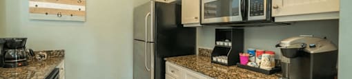 a kitchen with white cabinets and a black refrigerator