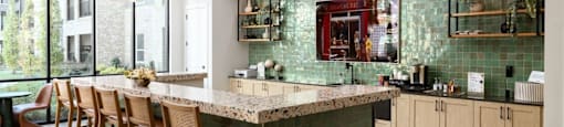 A kitchen with a green tiled backsplash and wooden chairs at Liam at Hays Farm in Huntsville, Alabama