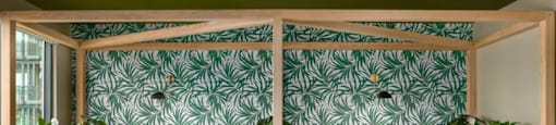 A room with a green wallpaper and wooden furniture at Boardwalk at Research Park apartments in Huntsville, AL.