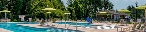 a swimming pool with chairs and umbrellas at the resort
