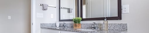 a bathroom with a vanity with two mirrors and a sink