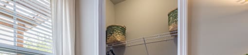 a walk in closet with a large window and a white curtain