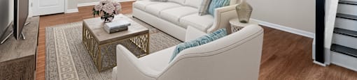 A living room with a white couch, a coffee table, and a ceiling fan.