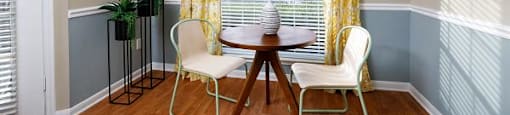 A dining room with a table and chairs.