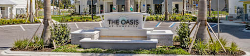 The Oasis is a modern residential complex with palm trees and white buildings.