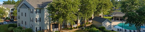 an aerial view of an apartment complex with green grass and trees