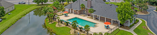an aerial view of a house with a pool and a lake