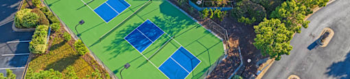 arial view of a tennis court and a clubhouse with a pool