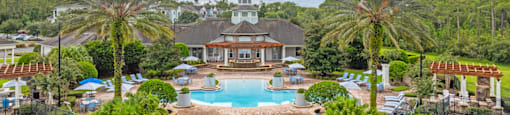 an aerial view of a resort swimming pool with palm trees