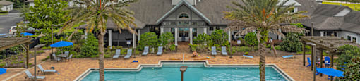 an aerial view of a swimming pool with palm trees