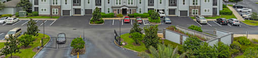an aerial view of a large apartment building with a parking lot