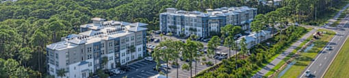 an aerial view of apartment buildings on the side of a road