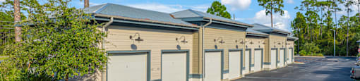 an empty parking lot with a row of garages