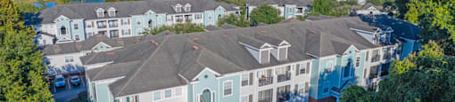 aerial view of the exterior of a large apartment building with green grass and trees