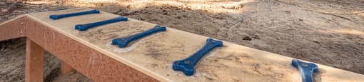 A sandbox with blue slides in the middle of a park.
