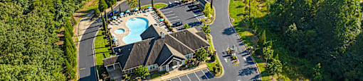 an aerial view of a resort with a swimming pool and parking lot