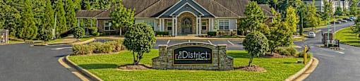 a large house with a driveway and a sign in front of it
