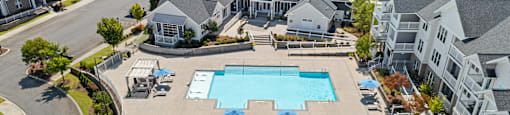 an aerial view of a large swimming pool in front of a row of houses