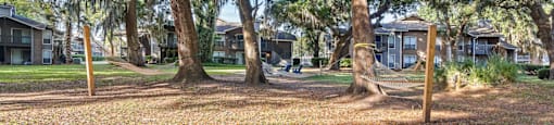 firepit and lounge area with hammocks under beautiful south carolina trees