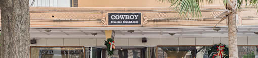 A storefront with a sign that says "S.H. Kress" above a sign that says "Cowboy" below it.