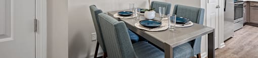a dining room with a table and chairs and a painting on the wall