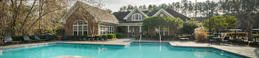 A large swimming pool in front of a house.