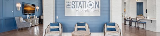 a living room with blue walls and a lobby with chairs and a table