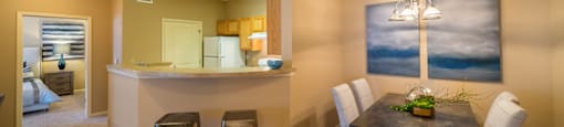 A kitchen area with a bar and a dining table.