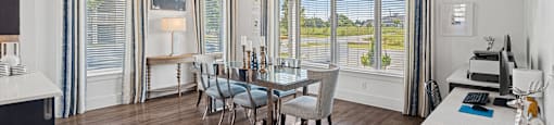a dining room with a table and chairs and large windows