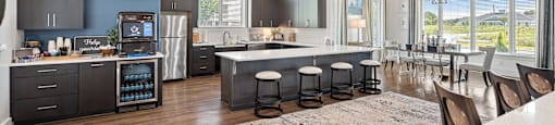 a kitchen with a large island and a dining room with a table and chairs