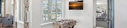 a game room with a foosball table and a window