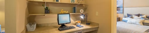 A home office with a desk, chair, and computer setup.