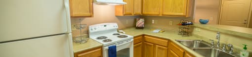 A kitchen with wooden cabinets and a white refrigerator.