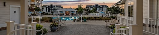 a view of a patio with a pool at sunset
