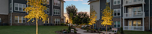 a sidewalk leading to an apartment building at sunset